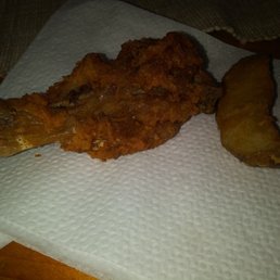 Dried up chicken leg next to mushy potato wedge Dried up chicken leg next to mushy potato wedge