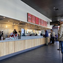 a man standing at the counter of a coffee shop a man standing at the counter of a coffee shop