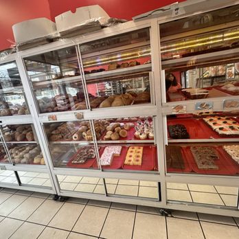 Salgados Bakery - A glass display case at Salgados Bakery in Chicago showcases an assortment of baked goods, including pastries, cookies, and cakes. - Bakeries Near Me - Chicago, Illinois