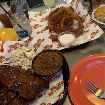 Phil's BBQ - Ribs with coleslaw and baked beans (front); onion rings (back) - Barbeque Near Me - San Diego, California Phil's BBQ - Ribs with coleslaw and baked beans (front); onion rings (back) - Barbeque Near Me - San Diego, California