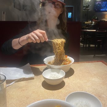 1 Mongolian BBQ - a woman eating noodles with chopsticks - Barbeque Near Me - Boise, Idaho