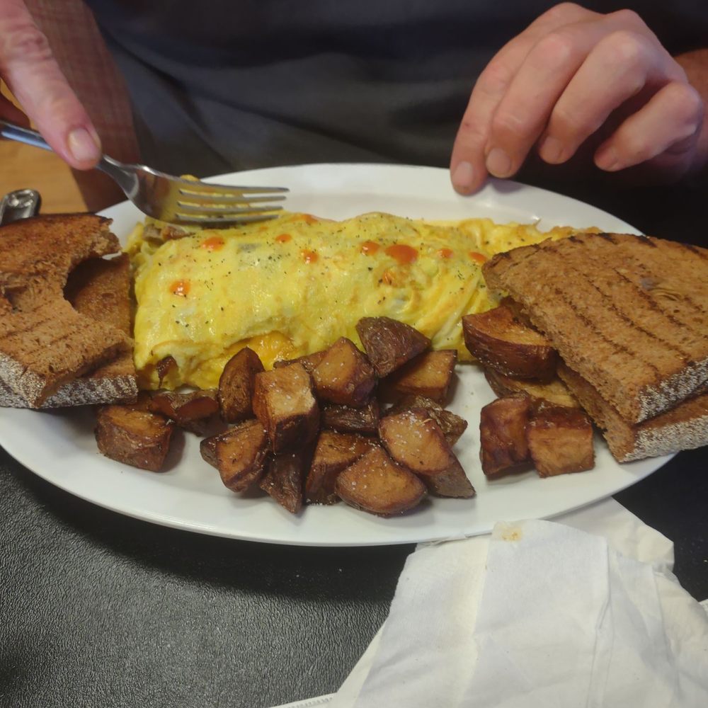 Meat lovers omelette with home fries and wheat bread Meat lovers omelette with home fries and wheat bread