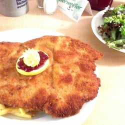 Postwirt - Postwirts Riesenschnitzel, schön rösch gebraten, mit Zitronenbutter, Preiselbeeren, Pommes Frites und gemischtem Salat
