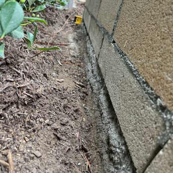 Jody Angevine Masonry - Yellow level in the back is sitting on top of patio/ground and is level. - Masonry/Concrete Near Me