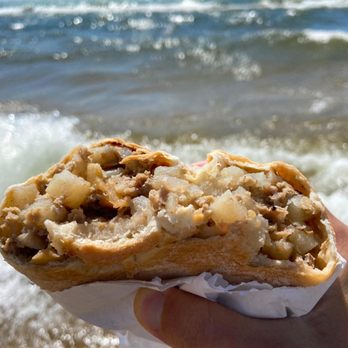 The Pasty Corner - a person's hand holding a pastry - American Near Me - Iron River, Michigan The Pasty Corner - a person's hand holding a pastry - American Near Me - Iron River, Michigan