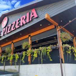 The Pie Pizzeria - Ogden - The Pie Pizzeria's spacious covered patio offers open-air dining surrounded by colorful flowers and greenery.