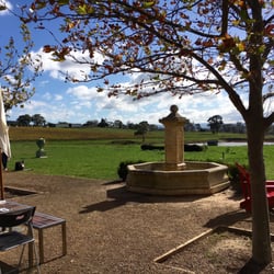 Dominique Portet - Outdoor seating overlooking a water fountain and the vineyards