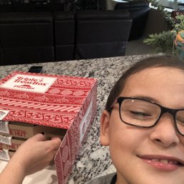 a young boy holding a pizza box