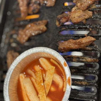 Buga Korean BBQ - a bowl of bbq sauce and ribs on a grill - Barbeque Near Me - San Diego, California Buga Korean BBQ - a bowl of bbq sauce and ribs on a grill - Barbeque Near Me - San Diego, California