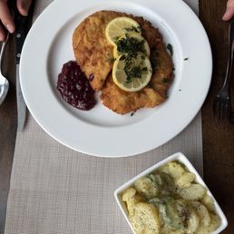 Pork Schnitzel with lingonberry sauce, Austrian potato salad, lemon and crispy parsley