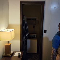 Hilltop Motel - Closet with A/C and microwave stacked on small fridge.