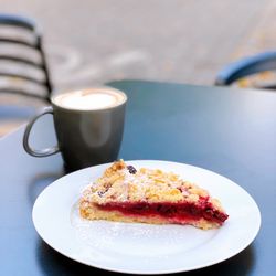 Cappuccino mit Hafermilch und ein Stück Kirschstreuselkuchen