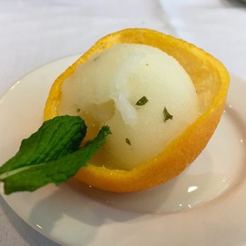 Courses - an orange cut in half with a mint leaf on top - New American Near Me - Houston, Texas