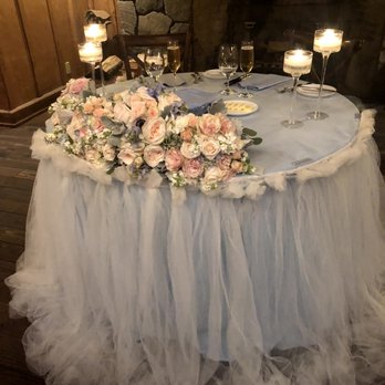 Queen Bridals - Sweetheart table with dusty blue linen and white tulle, candles, and re-purposed bouquets. - Wedding Planning Near Me - San Jose, California Queen Bridals - Sweetheart table with dusty blue linen and white tulle, candles, and re-purposed bouquets. - Wedding Planning Near Me - San Jose, California