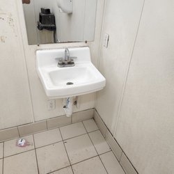 Soap dispenser on floor. Look how dirty the walls and floor are.