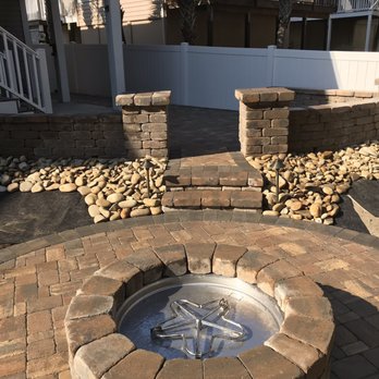 Seaside Scapes - a brick fire pit in a backyard - Landscaping Near Me