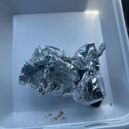 Aftermath of an asada burrito, no rice, extra cheese, onions, cilantro, guacamole Aftermath of an asada burrito, no rice, extra cheese, onions, cilantro, guacamole