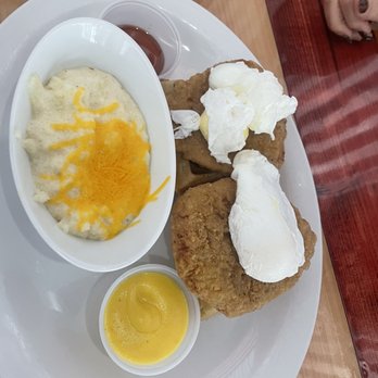 Untoasted - Those are attempted poached eggs on top of chicken and waffles. With a side of grits - Breakfast & Brunch Near Me - Hallandale Beach, Florida