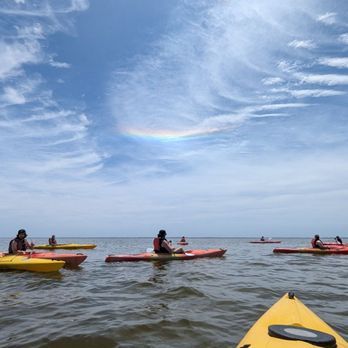 Coastal Explorations - Kayakers get their first glimpse of dog leg rainbow created by reflecting water droplets in the cloud - Rafting/Kayaking Near Me - Currituck, North Carolina Coastal Explorations - Kayakers get their first glimpse of dog leg rainbow created by reflecting water droplets in the cloud - Rafting/Kayaking Near Me - Currituck, North Carolina