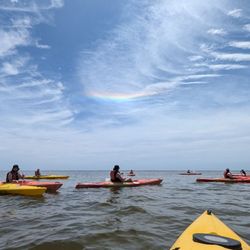 Kayakers get their first glimpse of dog leg rainbow created by reflecting water droplets in the cloud