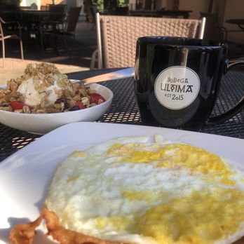 Bodega Ultima - BaconEggs black coffee and yogurt parfait The patio outside offers long tables furniture to lounge next to the fountain. - Coffee & Tea Near Me - Augusta, Georgia Bodega Ultima - BaconEggs black coffee and yogurt parfait The patio outside offers long tables furniture to lounge next to the fountain. - Coffee & Tea Near Me - Augusta, Georgia
