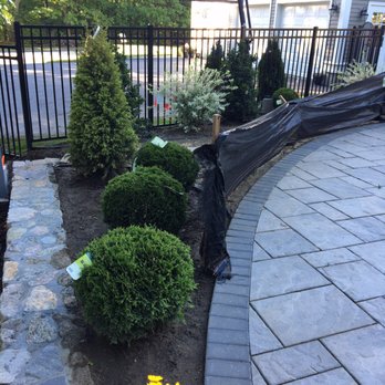 Mass Stone Landscape Construction - a black fence and yellow flowers - Landscaping Near Me - Framingham, Massachusetts
