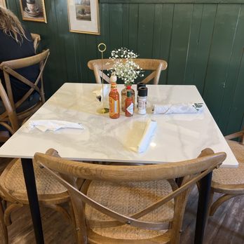 L’Amitié Bistro - a table and chairs in a restaurant - Breakfast & Brunch Near Me - Denton, Texas