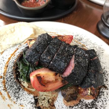 El Santo - CARNE AHUMADA Leek ash rubbed wagyu flank steak, red pepper and habanero purée, grilled tomato, sunchoke, Swiss chard, mesquite smoke. - Mexican Near Me - New Westminster, British Columbia