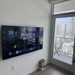 Grindlex Home Services - Flat screen TV mounted flush and level on a living room wall in a downtown LA high-rise by Grindlex Home Services.
