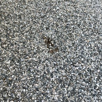 Kleen - The photograph captures a gravel surface made up of numerous small, rounded stones in various shades of gray, white, and black. In the middle of the image, there is a small patch of dark soil or dirt, contrasting with the surrounding gravel. The gravel appears evenly spread, with no visible structures or objects, and the focus is on the textured surface. - Home Cleaning Near Me - Pasadena, California