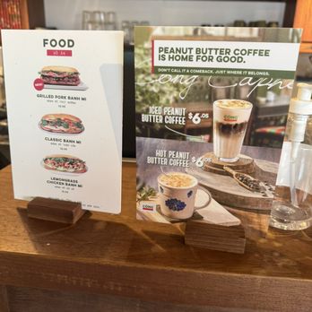 Cong Caphe - sandwiches & new items - Two menu signs on a wooden counter showcase food items like sandwiches and coffee options including peanut butter coffee at Cong Caphe. - Coffee & Tea Near Me - Toronto, Ontario