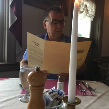 National Hotel - a man sitting at a table reading a menu - American Near Me - Leicester, New York National Hotel - a man sitting at a table reading a menu - American Near Me - Leicester, New York