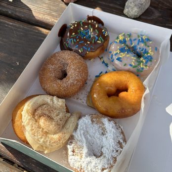 Reigning Doughnuts - Half dozen. Chocolate glazed with sprinkles, vanilla glazed with sprinkles, cinnamon sugar, honey glazed, apple cider buttercream, powdered - Donuts Near Me - Charlotte, North Carolina