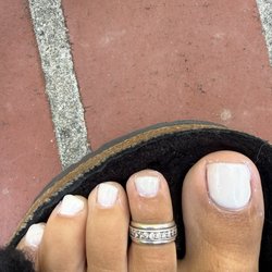TJ Salon & Nails - Color is leaking off the nail, the nails are crooked, she did 3 coats on one foot, 2 coats on the other.