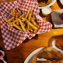 a plate of french fries and a basket of ketchup