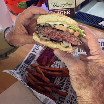 Doc Holidays Bar & Grill - a person holding a hamburger - Bars Near Me - Chattanooga, Tennessee Doc Holidays Bar & Grill - a person holding a hamburger - Bars Near Me - Chattanooga, Tennessee
