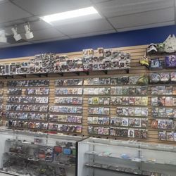 Video Game Geeks - Wide shot of the stores right most game wall and glass cases