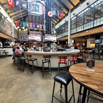 Guy Fieri's Smokehouse - Food court seating area with bar in the center and large screen TVs - Smokehouse Near Me - Norfolk, Virginia