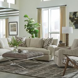 Earla's Furniture & Design Center - Contemporary sectional with faux leather tufted cocktail table & swivel chair.