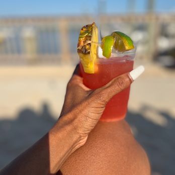 Dox - a person holding a drink on the beach - New American Near Me - Island Park, New York Dox - a person holding a drink on the beach - New American Near Me - Island Park, New York