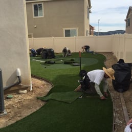 a man working on a putting green a man working on a putting green