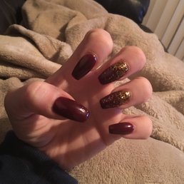 Coffin shaped acrylic nails with dark red polish and gold glitter Coffin shaped acrylic nails with dark red polish and gold glitter