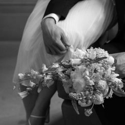 Samson Photography - Filmic details of a grooms arms wrapped around a perched bride.