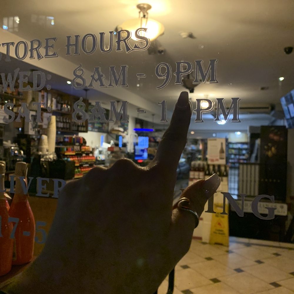 Giorgiana's - a hand pointing at the store hours window - Beer, Wine & Spirits Near Me - Boston, Massachusetts