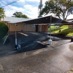The new location, behind the church. Use the road going up to the school to access.