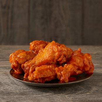 Checkers - a plate of buffalo wings on a wooden table - Burgers Near Me - Hudson, Florida