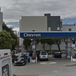 a gas station with cars parked in front of it a gas station with cars parked in front of it