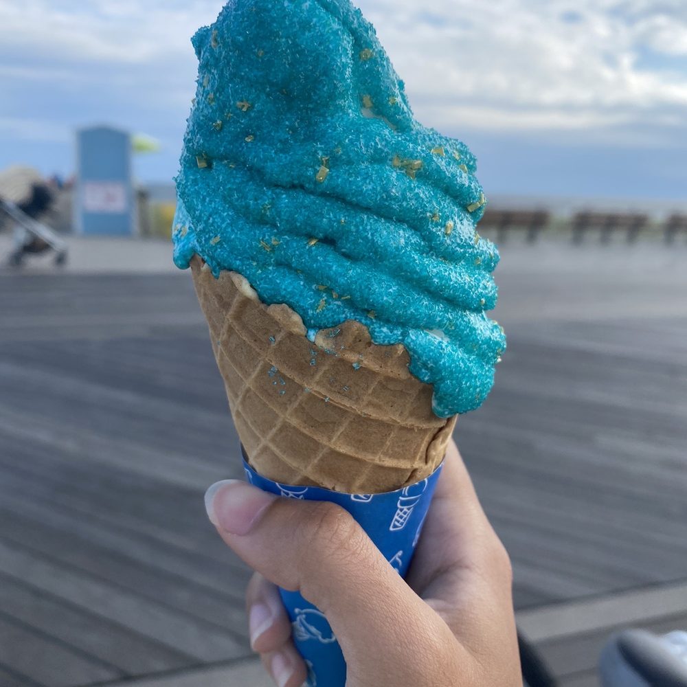 a hand holding a cone of ice cream a hand holding a cone of ice cream