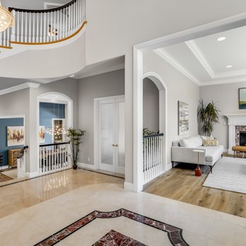 Draou Dime - a living room with a fireplace and a staircase - Flooring Near Me