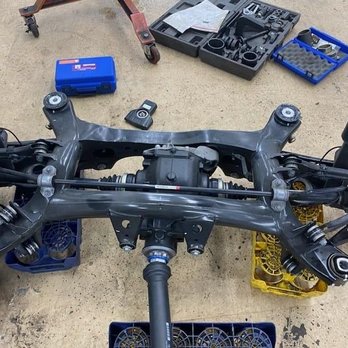 Beamer Auto - entire subframe removal - Disassembled vehicle subframe on the ground with tools and parts around it, indicating repair or maintenance work. - Auto Repair Near Me - Clinton, Maryland